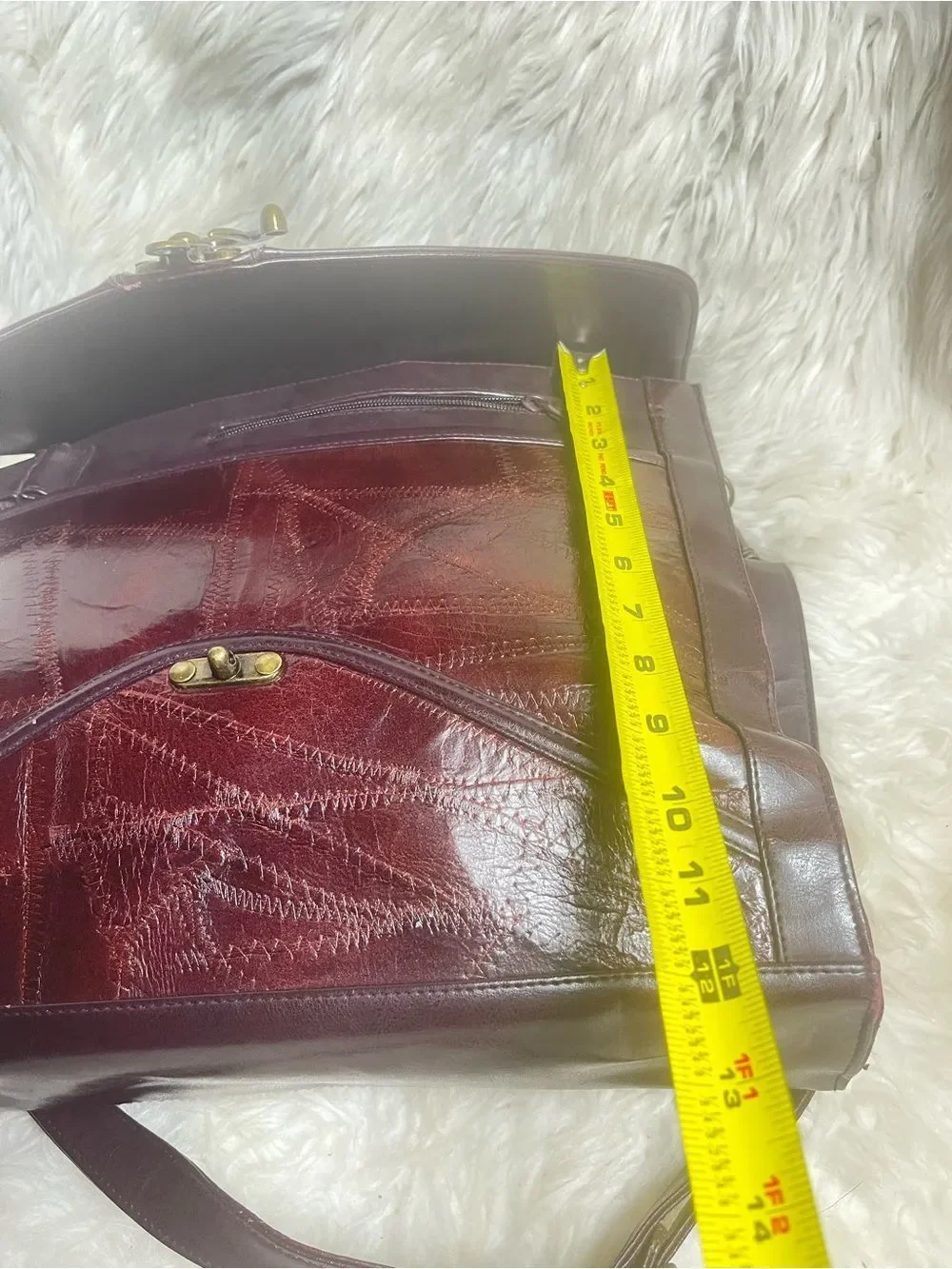M.C textured leather patchwork like stitched accent burgundy leather bag .